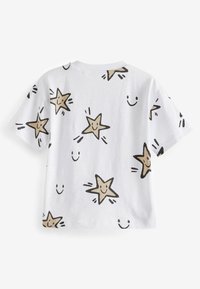 Camiseta blanca de manga corta con un patrón de estrellas beige y caras sonrientes. Textura suave, escote redondeado y corte relajado.