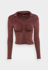 Blusa de manga longa na cor ferrugem, com detalhe franzido na frente, um decote em V profundo e collar. Feita de um tecido suave e ligeiramente brilhante.