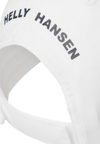 Gorra de béisbol blanca con "HELly HANSEN" bordado en negro en la parte delantera. El diseño incluye una visera curva y una correa ajustable en la parte trasera.