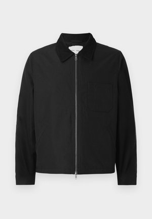Veste zipée noire à manches longues avec col, une poche poitrine et deux poches latérales, présentée sur un fond blanc.