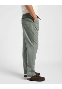 Vaaleanvihreät, hengittävät kangashousut, joissa on joustava vyötärö ja nyöri. Sisältää sivutaskut ja yhden takataskun.