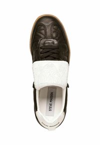 Sneaker in pelle nera con texture trapuntata, sovrapposizione in pelle bianca con design embossato, suola in gomma marrone e lacci neri. Etichetta del marchio visibile.