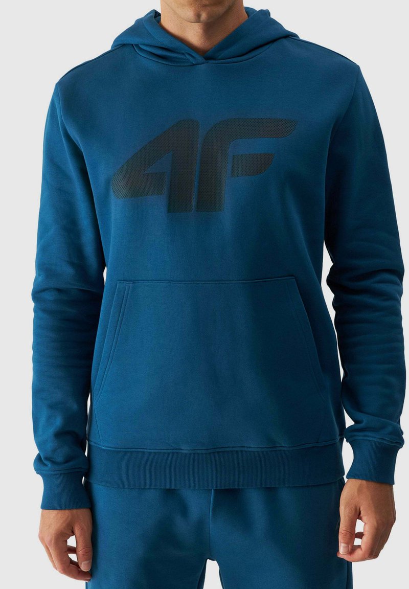 Sudadera ligera en color teal con logo negro, con bolsillo tipo canguro, puños y bajo acanalados, hecha de una suave mezcla de algodón.