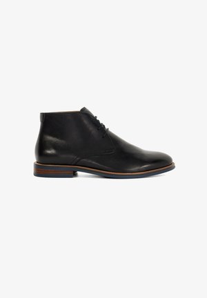 Bottines en cuir noir avec une texture lisse, bout rond, lacets minimalistes et un contour brun contrastant sur la semelle.