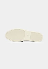 White rubber shoe sole with textured grooves and a rounded toe, featuring a smooth surface and minimal branding on the side.