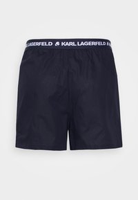 Námornícke modré šortky vyrobené z ľahkého materiálu, s elastickým pásom a bielym logom "KARL LAGERFELD" a hladkou textúrou.