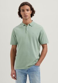 Lys grøn polo skjorte laget av myk stoff, med klassisk krage, tre-knapps placket og en liten brodert logo på brystet.