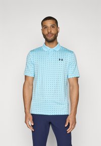 Cămașă polo bleu deschis cu un model punctat, mâneci scurte și guler. Are un logo contrastant negru pe piept.