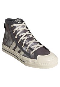 Vysoké tenisky s šedým textilním svrškem, krémovou gumovou podrážkou, třemi proužkovými akcenty a béžovými tkaničkami s polstrovaným límcem.