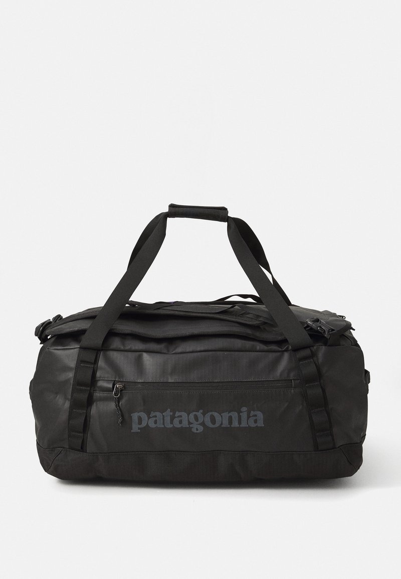Black Patagonia duffel bag with dual carrying straps and zippered front pocket on a white background.