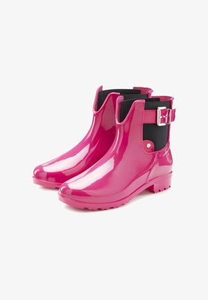 Pink patent rubber ankle boots with a black elastic side panel, a strap and buckle detail, and a textured sole for traction.
