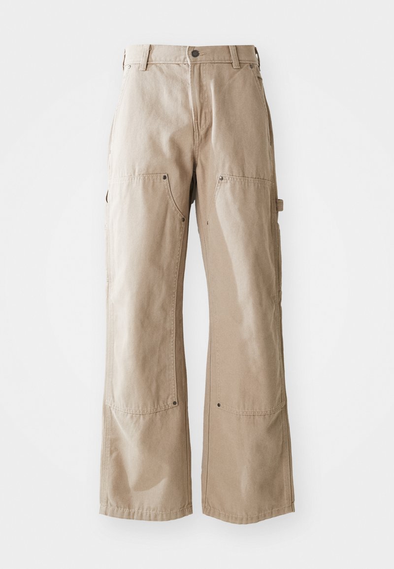 Pantaloni beige a gamba larga realizzati in robusto tessuto di cotone. Presentano tasche anteriori e laterali, cuciture a vista e dettagli in metallo sulle tasche.