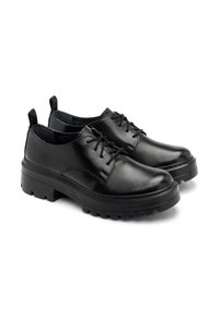 Scarpe di pelle nere con finitura liscia, punta rotonda, design con lacci e suola in gomma nera spessa con motivo scolpito.