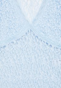 Tissu en dentelle bleu clair avec des motifs floraux et une couture centrale formant un X.