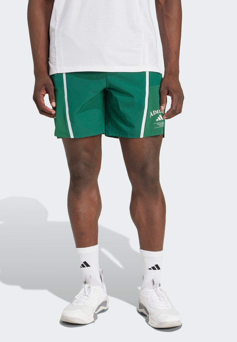 Žalios sportinės šortai, pagaminti iš lengvos medžiagos, su baltais šoninėmis juostelėmis, logotipu šone ir klasikinio sportinio dizaino.