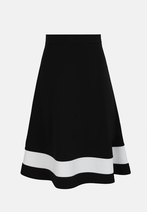 Jupe noire en ligne A avec une large bande horizontale blanche près de l'ourlet, taille ajustée et longueur genou sur fond uni.
