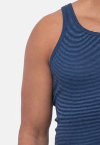 Granatowy pasiasty top na ramiączkach wykonany z miękkiej bawełny. Posiada okrągły dekolt i wąskie ramiączka, z dopasowanym krojem.