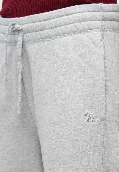 Pelēki kokvilnas sporta bikses ar auklu jostasvietā, ar ribotu jostasvietu un nelielu izšūtu dzīvnieku dizainu augšstilbā.