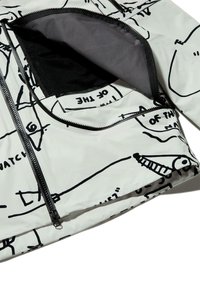 Biała kurtka zapinana na zamek z czarnymi wzorami graficznymi, wyposażona w dużą przednią kieszeń oraz gładką, błyszczącą fakturę.