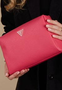 Roze synthetische clutch met een gestructureerd oppervlak, driehoekig zilveren logo, ritsluiting en een slanke rechthoekige vorm.