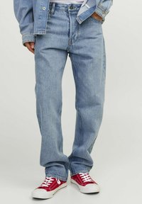 Jeans drept de culoare albastru deschis, din denim, cu un design clasic cu cinci buzunare. Asortați cu adidași din pânză roșie.