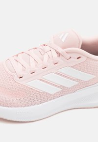  Lichtroze sportschoen met een bovenwerk van mesh, een ontwerp met witte strepen, textuurdetails en Cloudfoam-demping in de zool.