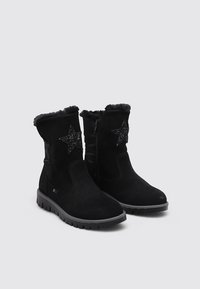 Botines de ante negros con un suave cuello negro, cremallera lateral y un acento en forma de estrella negra brillante en el lado exterior. Suela de goma.