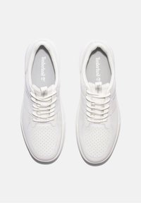Sneaker bianche con tomaia in pelle liscia, punta perforata, lacci piatti e soletta imbottita grigia con logo Timberland.