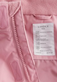 Rosa barnjacka med mjuk fleece inuti, vattentätt material, tejpade sömmar och en tvättlapp som beskriver funktioner och storlekar.