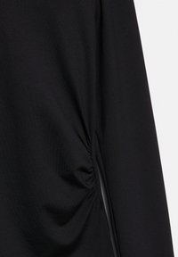 Fekete szövet, oldalvarrásnál gyűrött részletekkel, sima textúrával és hosszú ujjakkal.