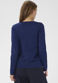 Marineblauer Pullover mit langen Ärmeln, rundem Ausschnitt und glatter Textur, mit figurbetonter Silhouette und dezenten Nähten.