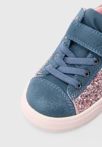 Zila zamšādas sporta apavi ar rozā un lavandas krāsas spīduma akcentiem. Ir apaļa pirkstu daļa, auklu aizdare un gumijas zole ar teksturētu virsmu.