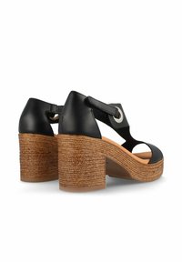 Sandalias de tacón de cuero negro con plataforma de yute trenzado, que cuentan con una correa para el tobillo y detalle metálico circular.
