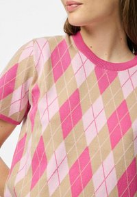 Pletený svetr se vzorem diamantu v odstínech růžové a béžové, s růžovým žebrovaným výstřihem a krátkými rukávy.