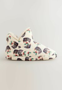 Fleece slippers med en cremfarget base, der prydes av et festlig mønster av kristtorn og leopardmønster. Myk innvendig og skrå krage for komfort.