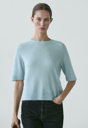 Maglione azzurro chiaro a maniche corte con scollo rotondo, polsini e orlo a coste. Texture morbida e vestibilità rilassata con cuciture sottili.