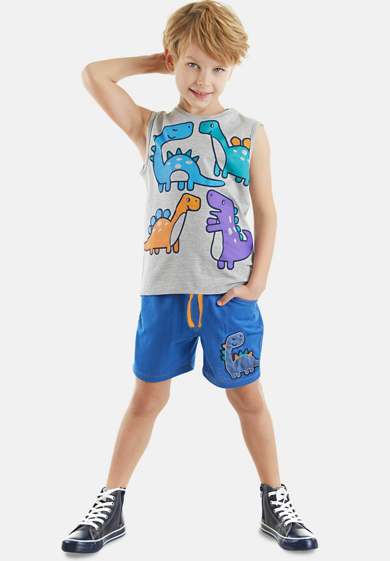 Gray sleeveless shirt with colorful dinosaur prints; blue shorts with orange drawstring and a dinosaur patch on the pocket; black high-top sneakers.