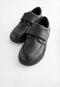 Pair of black leather shoes with wide Velcro straps on a white background.
