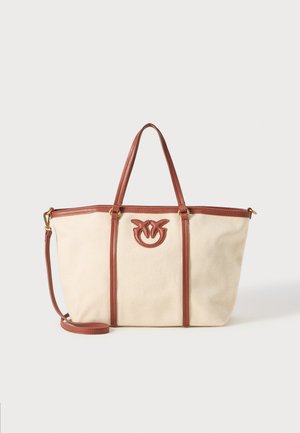 Platnena torba u krem boji s smeškim kožnim detaljima. Sadrži dvostruke ručke i podesivu crossbody traku. Upečatljiv logo na prednjoj strani.