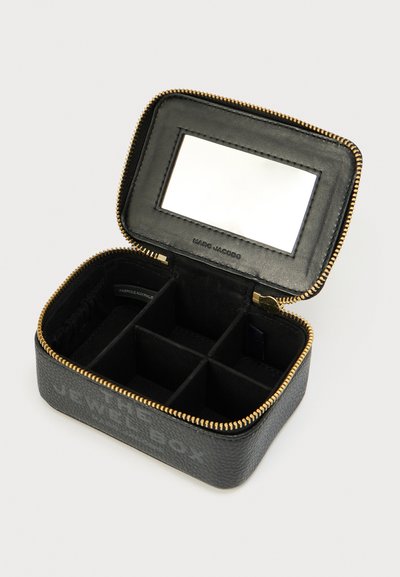 Μαύρο κουτί κοσμημάτων από δέρμα με χρυστό φερμουάρ, εσωτερικές θήκες και καθρέφτη στο καπάκι. Διαθέτει ανάγλυφο κείμενο στην εξωτερική πλευρά.