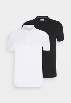 Deux chemises polo, l'une blanche et l'autre noire, en coton, à manches courtes, avec patte de boutonnage et col standard. Design simple, sans motifs.