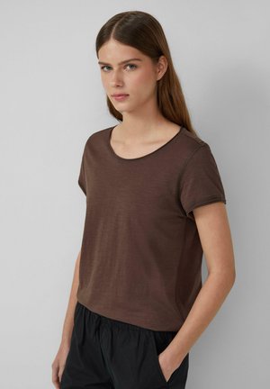 Bruine T-shirt met korte mouwen en een ronde hals, gemaakt van een zachte stof. Het ontwerp heeft een relaxte pasvorm en subtiele stikdetails.