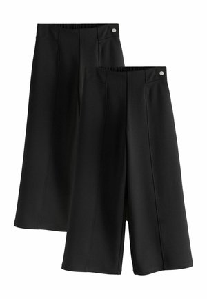 Deux paires de pantalons culottes noirs à jambes larges avec des détails de couture devant et des boutons argentés à la taille.