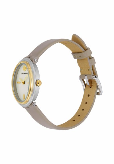 Reloj de pulsera redondo Tory Burch con caja de oro y plata, correa de cuero beige, esfera blanca minimalista y marcadores de hora y agujas doradas.