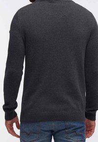 Antracietgrijze gebreide trui met een geribbelde textuur, lange mouwen en een ronde hals, met een losse pasvorm en contrasterende manchetten.