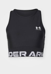 Černý sportovní crop top vyrobený z hladké látky, s širokým bílým logem Under Armour na lemu a kulatým výstřihem.