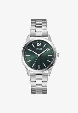 Męski zegarek na rękę z metalową srebrną kopertą, ciemnozieloną tarczą, srebrnymi indeksami godzin i logo „GUESS” poniżej cyfry 12.