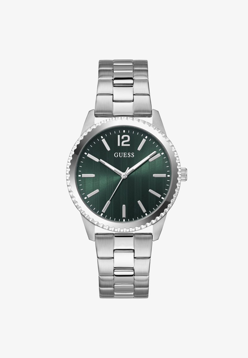 Ανδρικό ασημένιο μεταλλικό ρολόι χειρός με σκούρο πράσινο καντράν, ασημένιους δείκτες ώρας και λογότυπο "GUESS" κάτω από τον αριθμό 12.