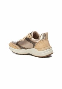 Zapatilla beige y metálica con acentos texturizados, superficies lisas, punta redonda, diseño de cordones y una suela blanca acolchada.