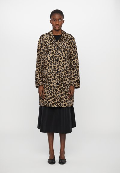 Cappotto a stampa leopardata in tessuto marrone e nero, caratterizzato da una vestibilità rilassata, chiusura a un solo bottone e maniche lunghe. Indossato sopra una gonna nera.